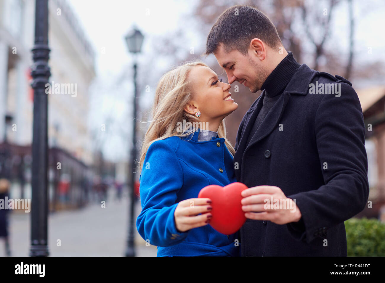 A loving couple in a coat with balloons hearts in hands Stock Photo - Alamy