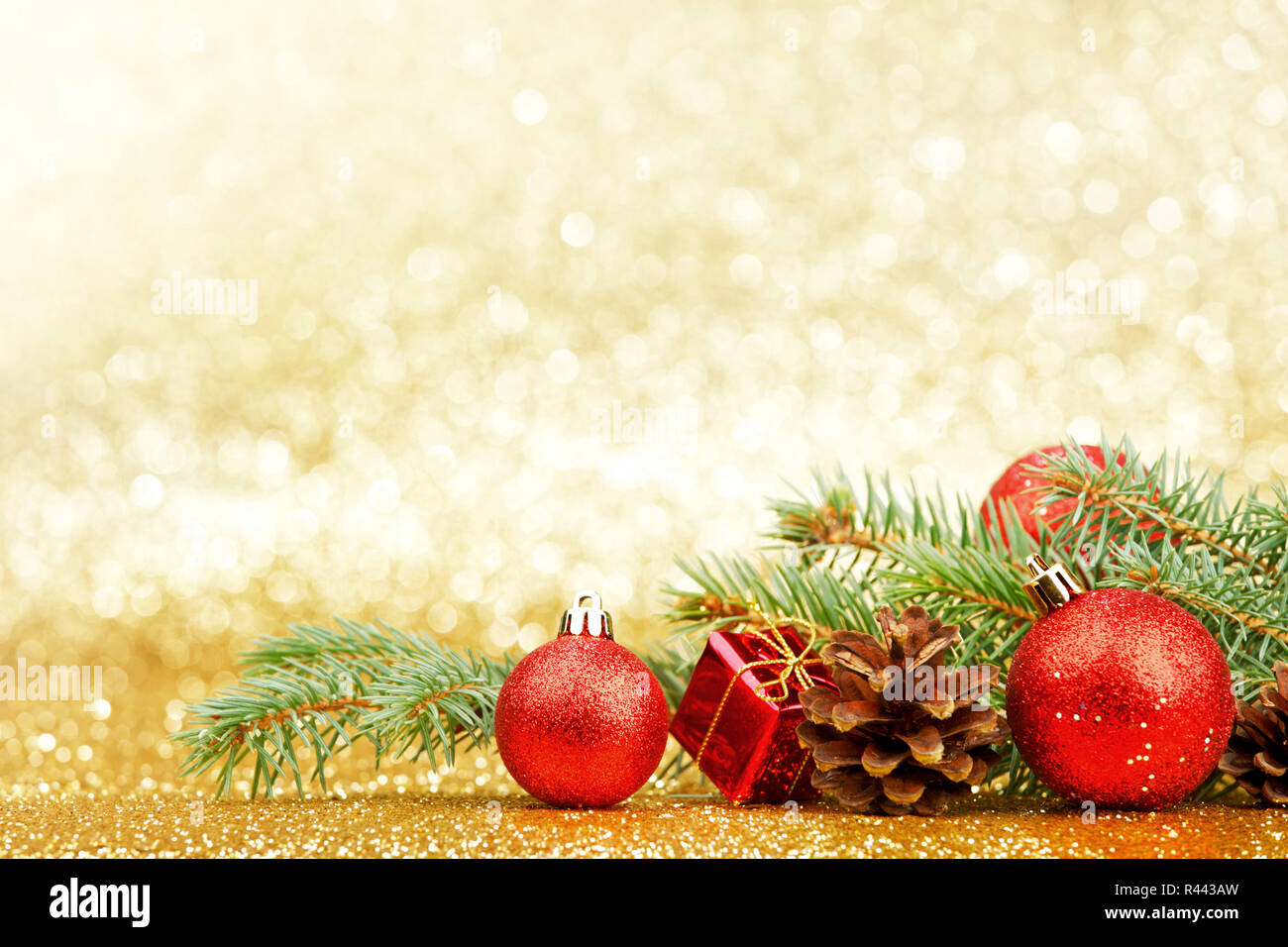 Christmas card with fir tree branch and decoration on golden glitter ...