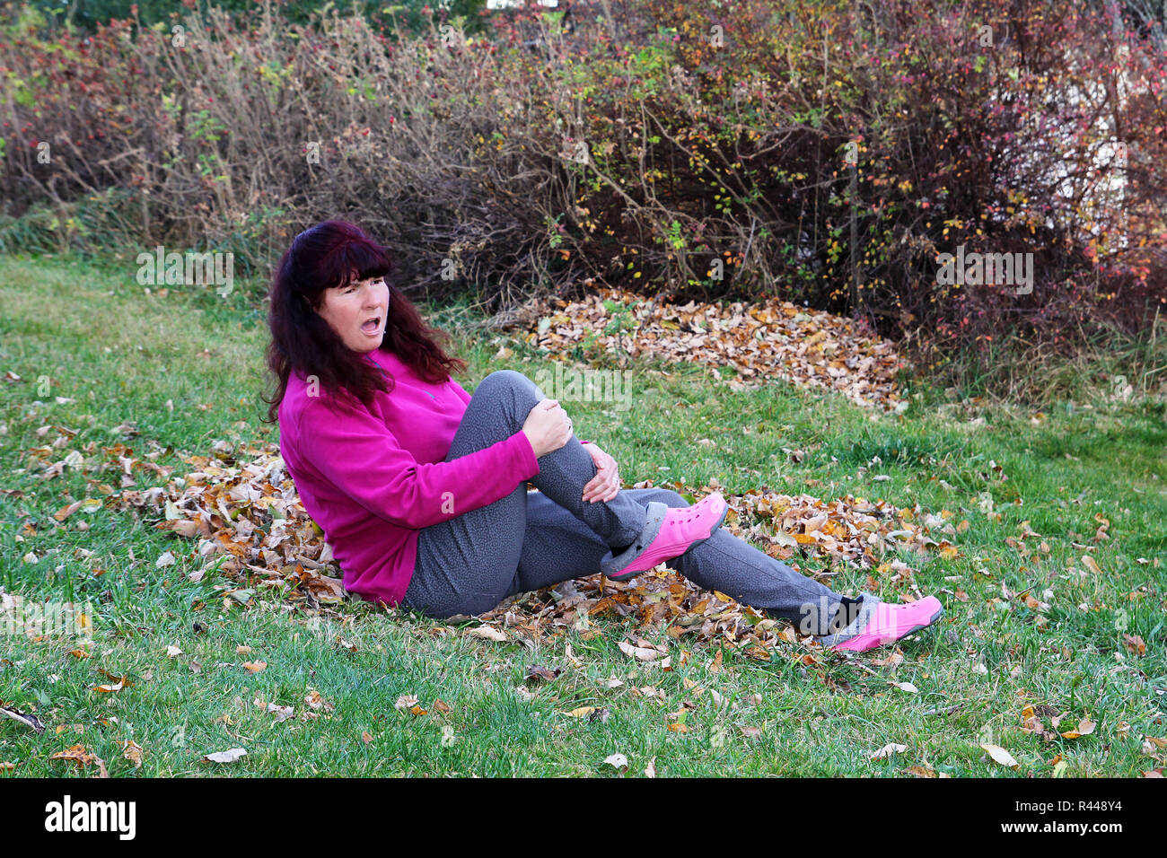 autumn - danger of accidents by slipping on wet leaves. a woman slipped on wet leaves Stock Photo