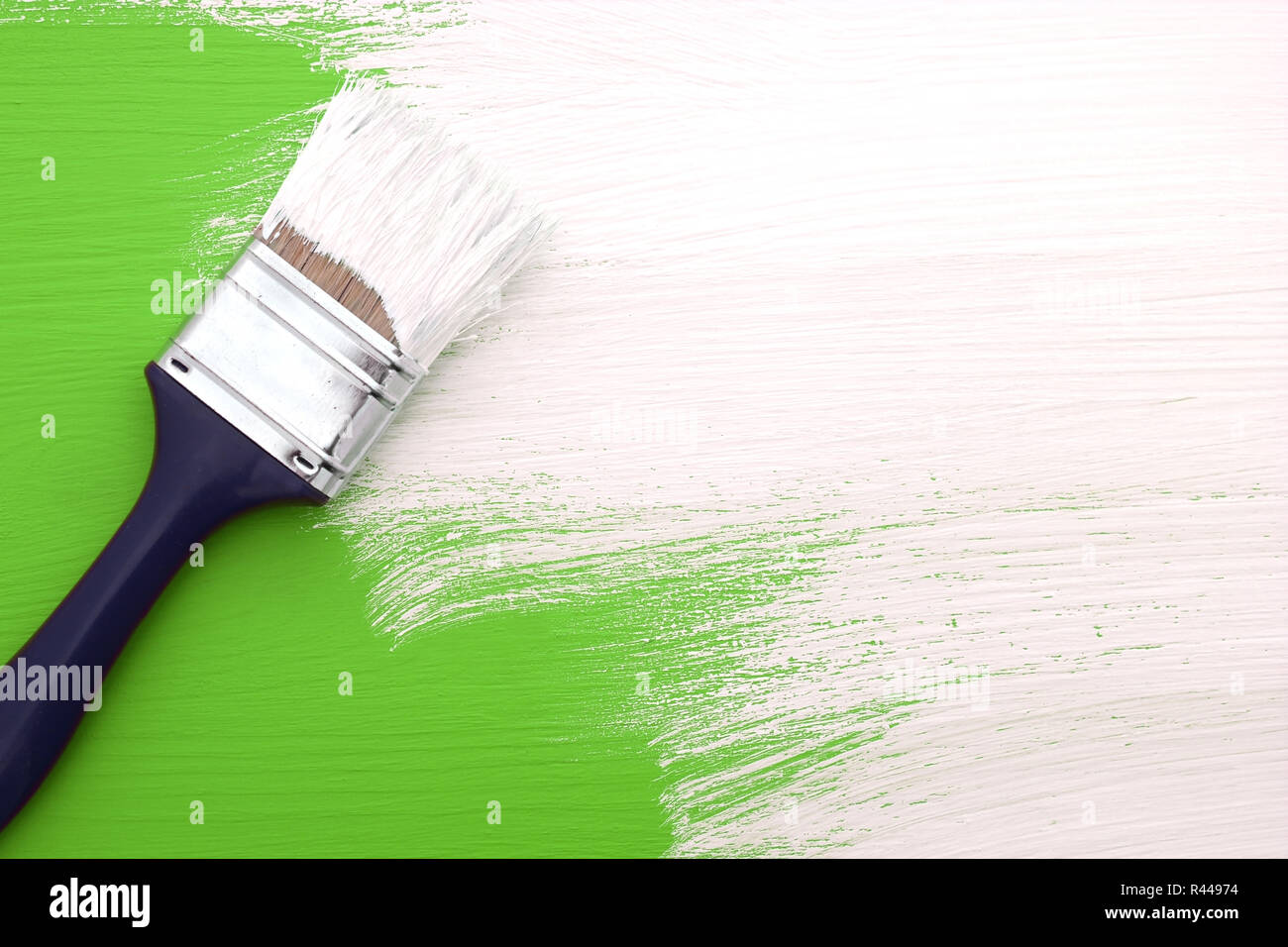 Paintbrush with white paint painting over green Stock Photo Alamy