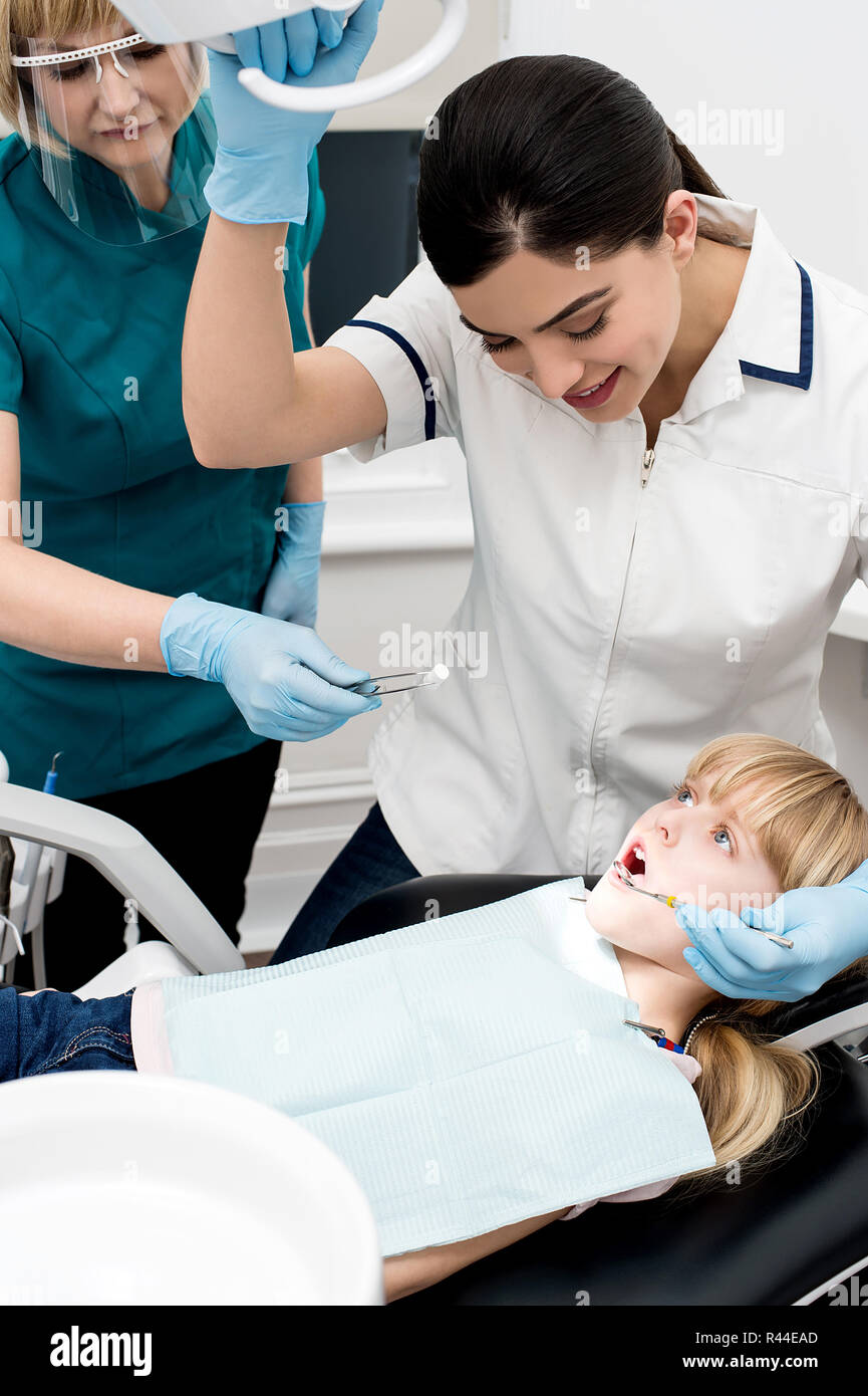 Lady dentist checking girl's teeth Stock Photo Alamy