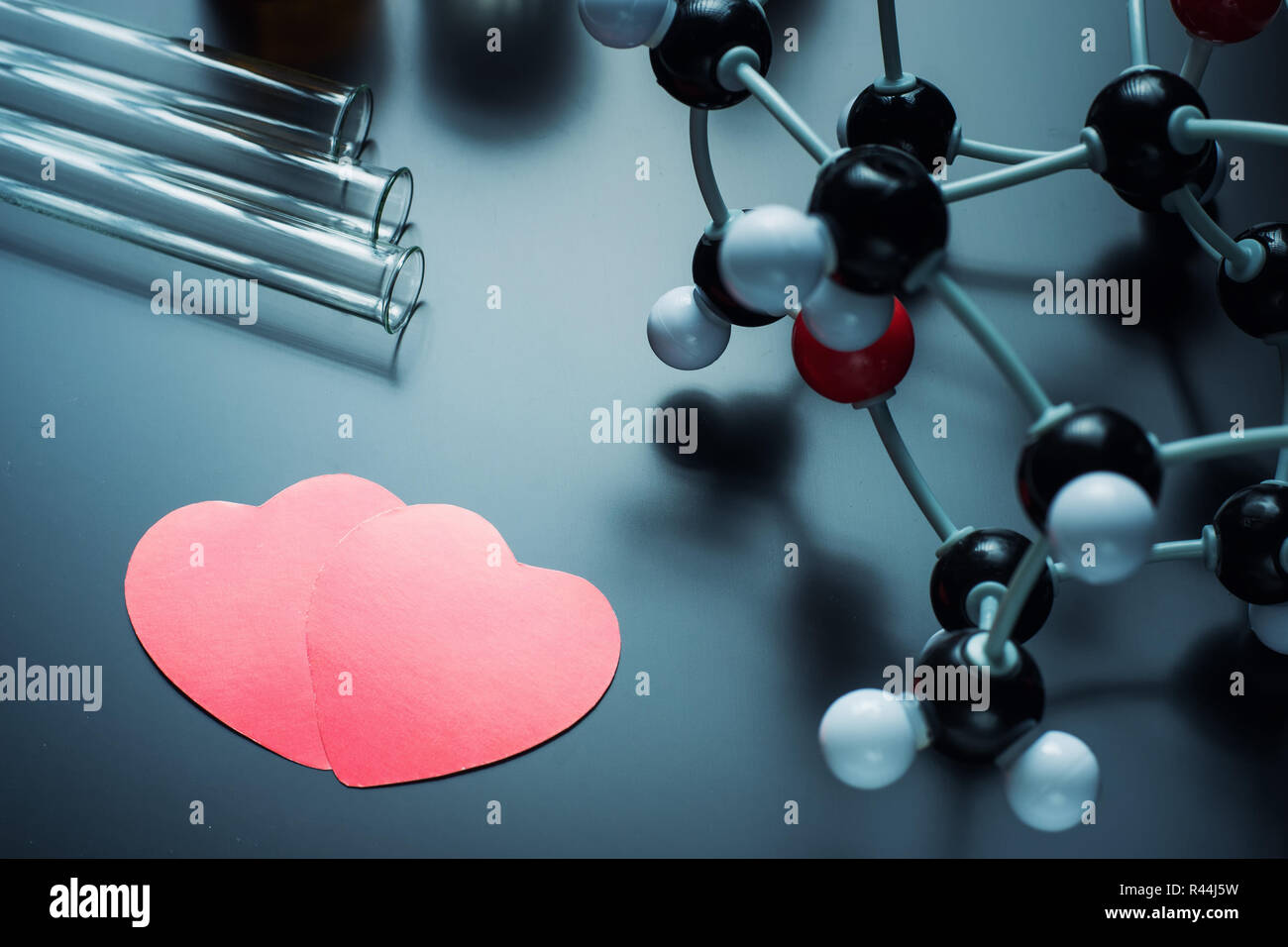 Two red paper hearts and molecular structure model on black background.  Love chemistry concept Stock Photo - Alamy