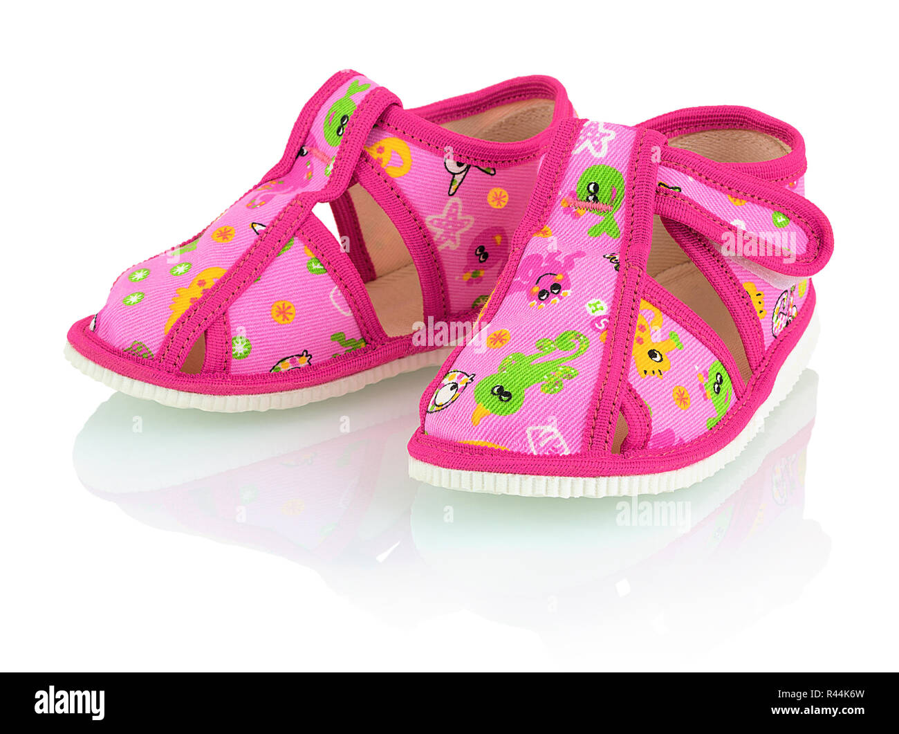 Children's pink slippers isolated on the white background with shadow reflection. Kid's pink softie shoes with sea animals, isolated on white backdrop Stock Photo