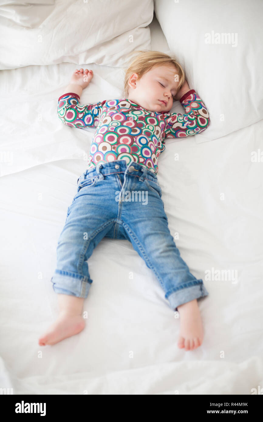 jeans baby sleeping on white bed Stock Photo Alamy