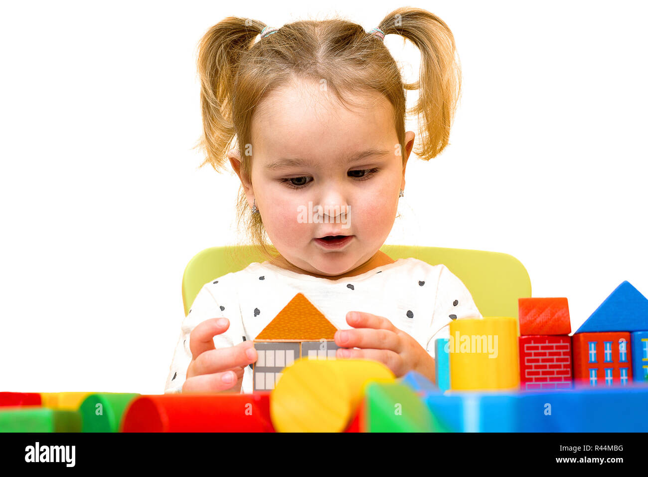 Toddler girl is playing with colorful wooden blocks over white background.  Toddler is building a house out of blocks. Blond hair toddler girl plays wi  Stock Photo - Alamy