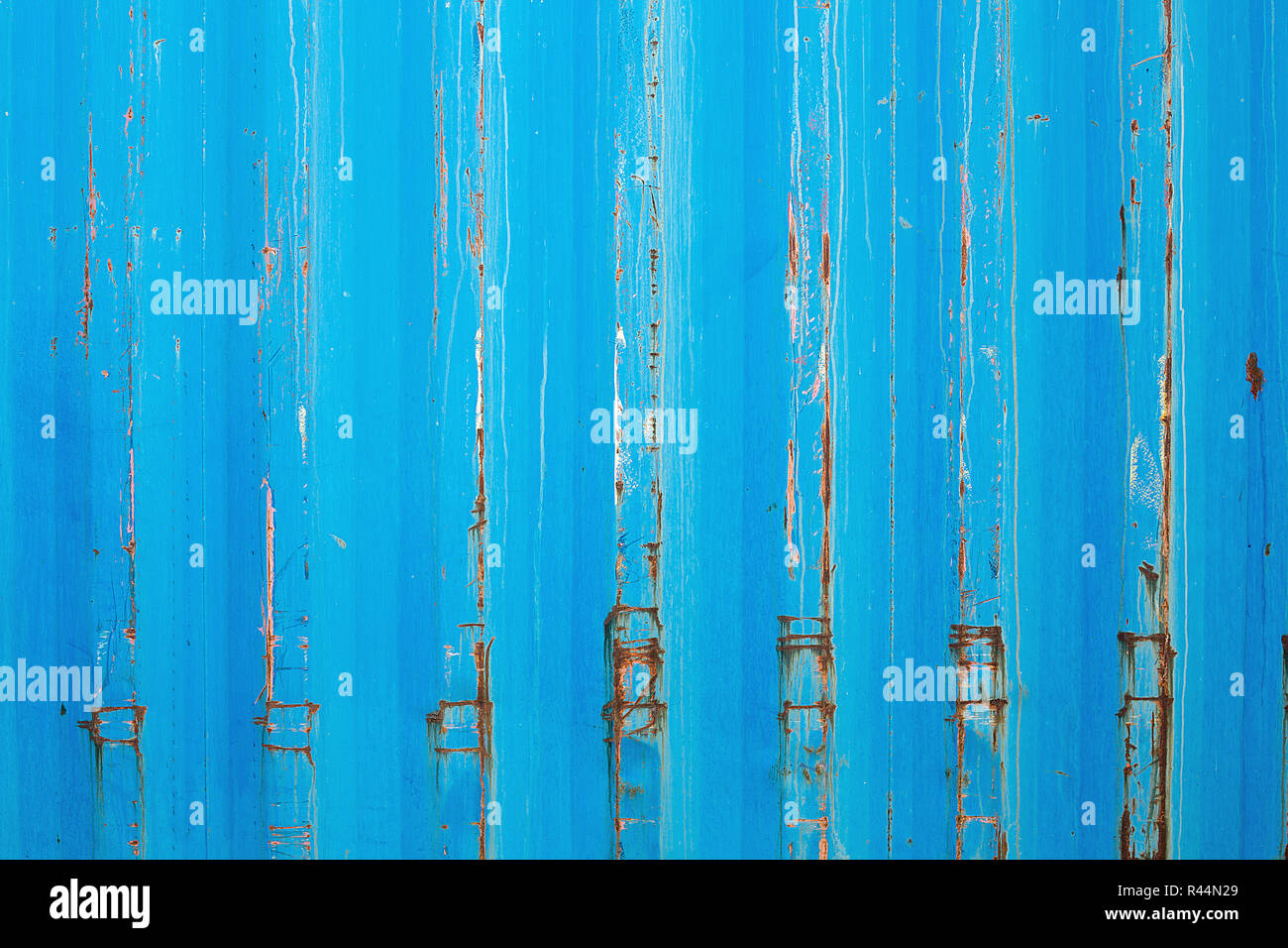 Rusty surface of metal plate with blue cracked color paint. Rust on old colored metal. Old blue fence. Grunge ruststained metal fence. Rust on blue ir Stock Photo