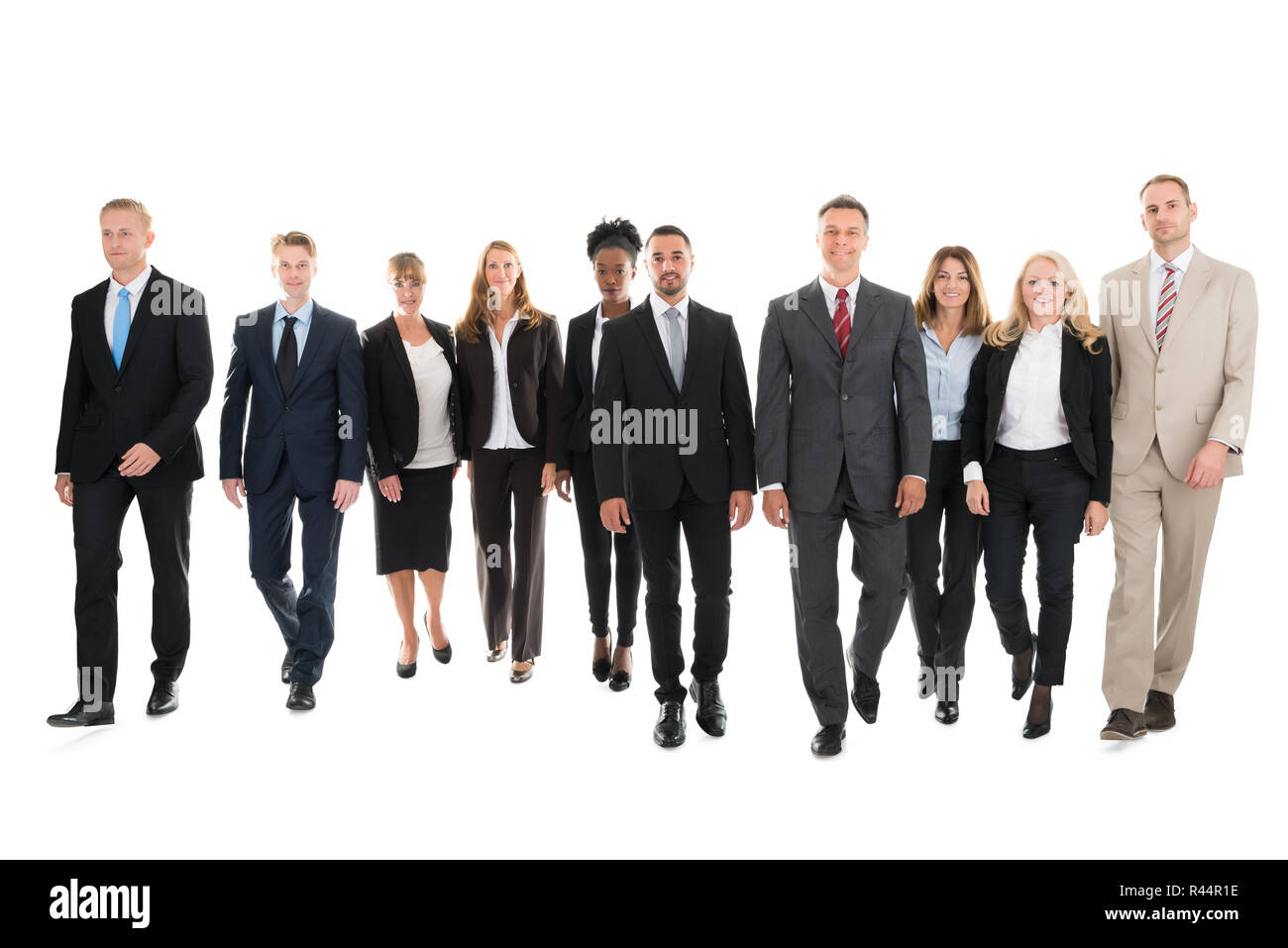 Confident Business Team Walking Against White Background Stock Photo
