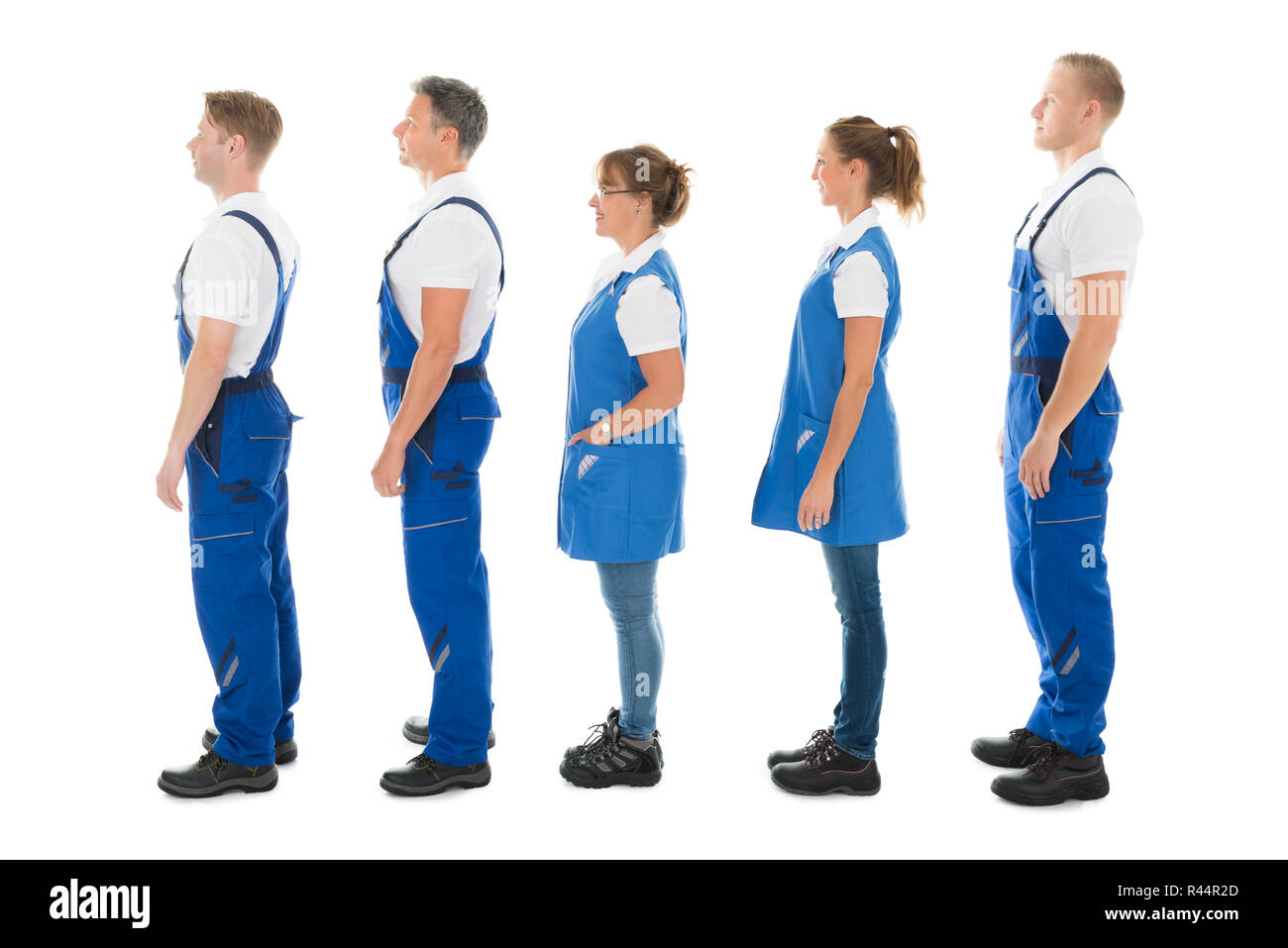 Side View Of Janitors Standing In Queue Stock Photo