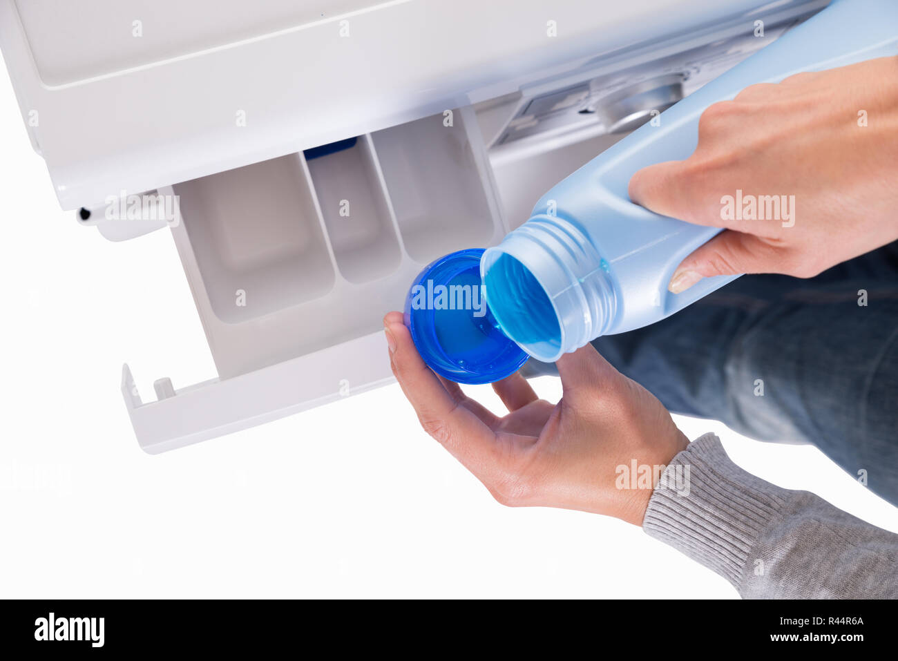 Woman Pouring Liquid Detergent In Lid For Washing Machine Stock Photo