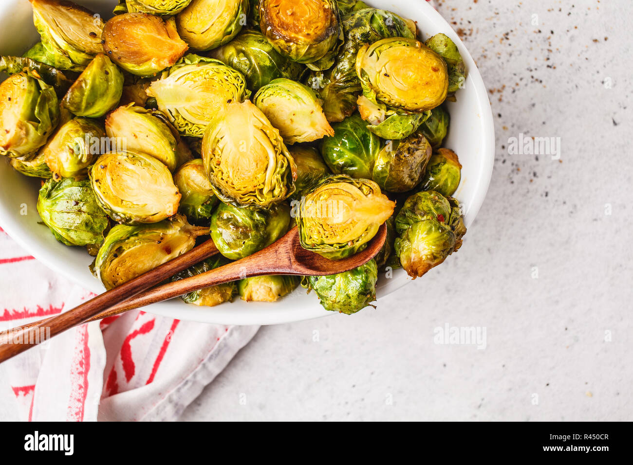 Baked brussels sprouts on a white plate. Plant based diet concept. Stock Photo