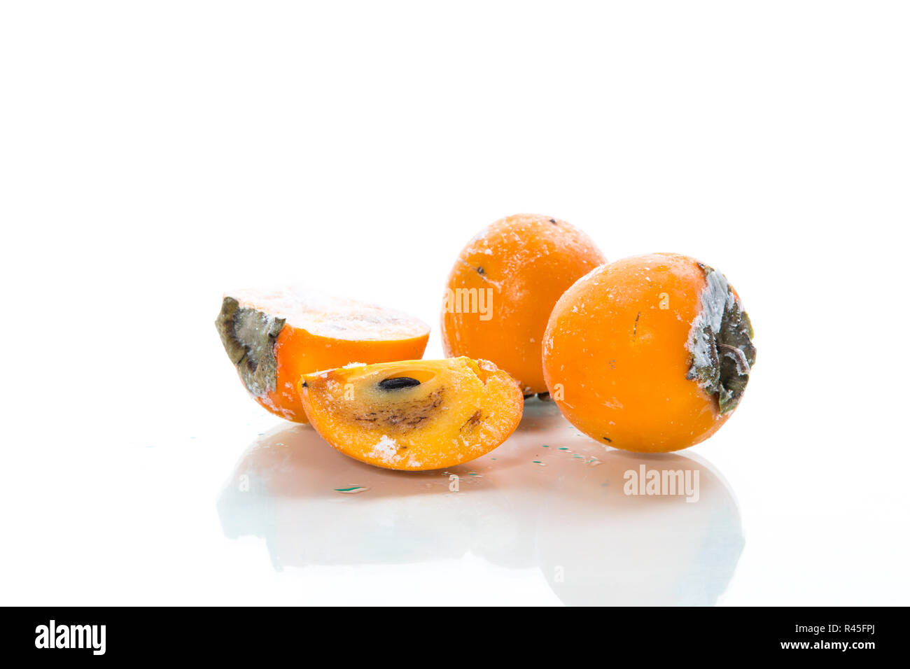 frozen ripe persimmon in ice isolated on white Stock Photo - Alamy