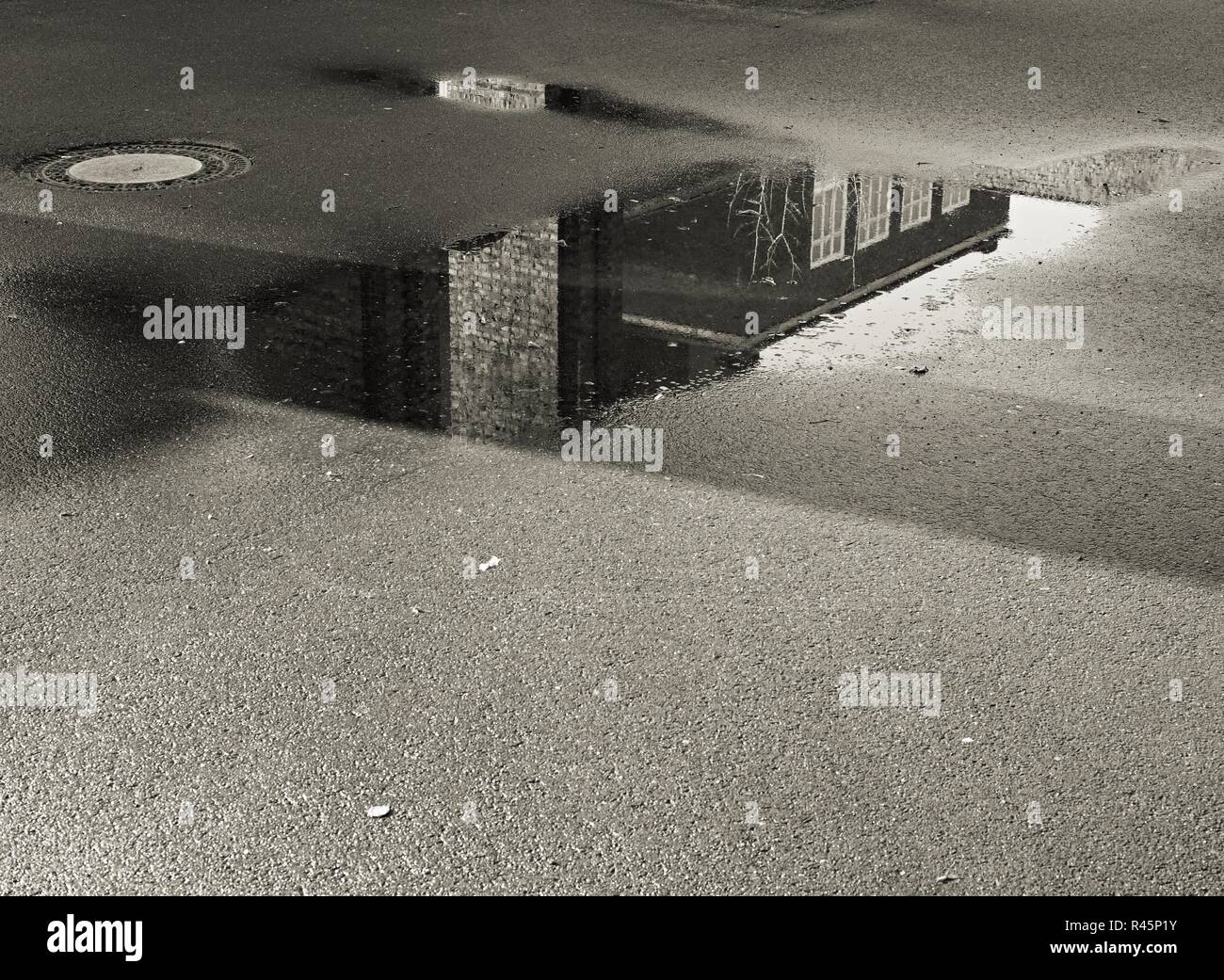 reflection of a building in a puddle Stock Photo - Alamy