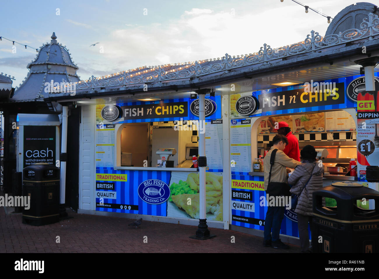 BRIGHTON, EAST SUSSEX, ENGLAND, UK - NOVEMBER 13, 2018: Customers buying street food from a traditional British fish and chips takeaway. Stock Photo