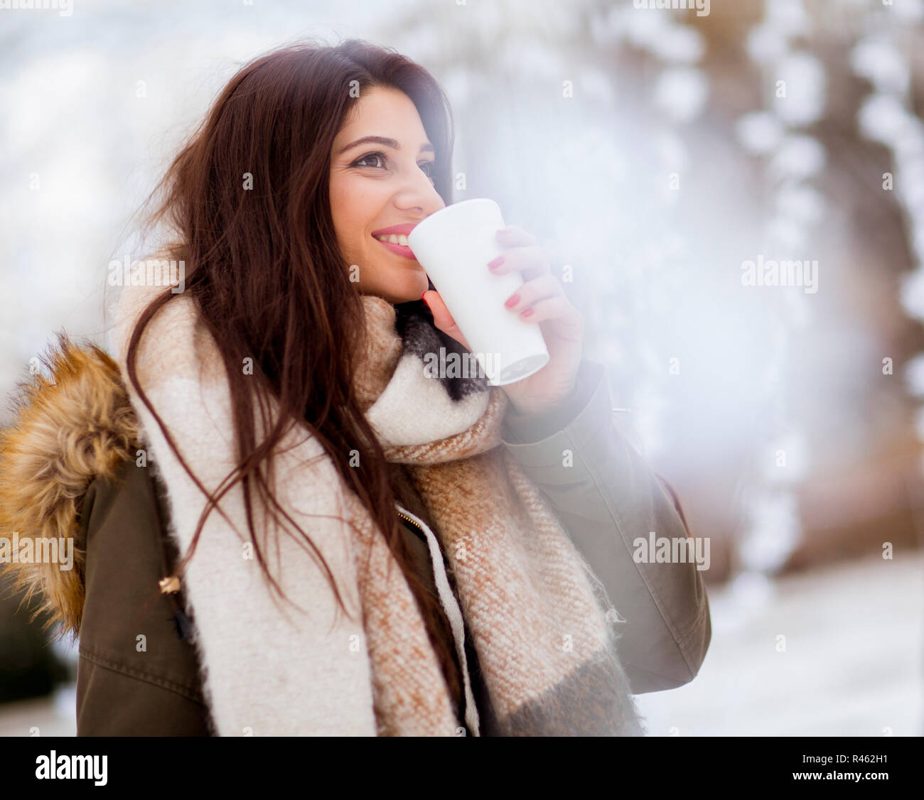 Portrait of young woman in a snow park drinks tea Stock Photo - Alamy