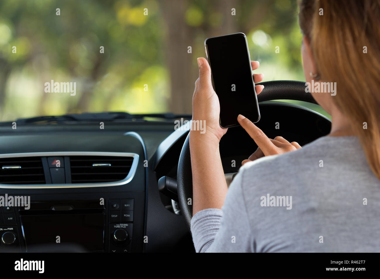 woman using phone in car on road Stock Photo