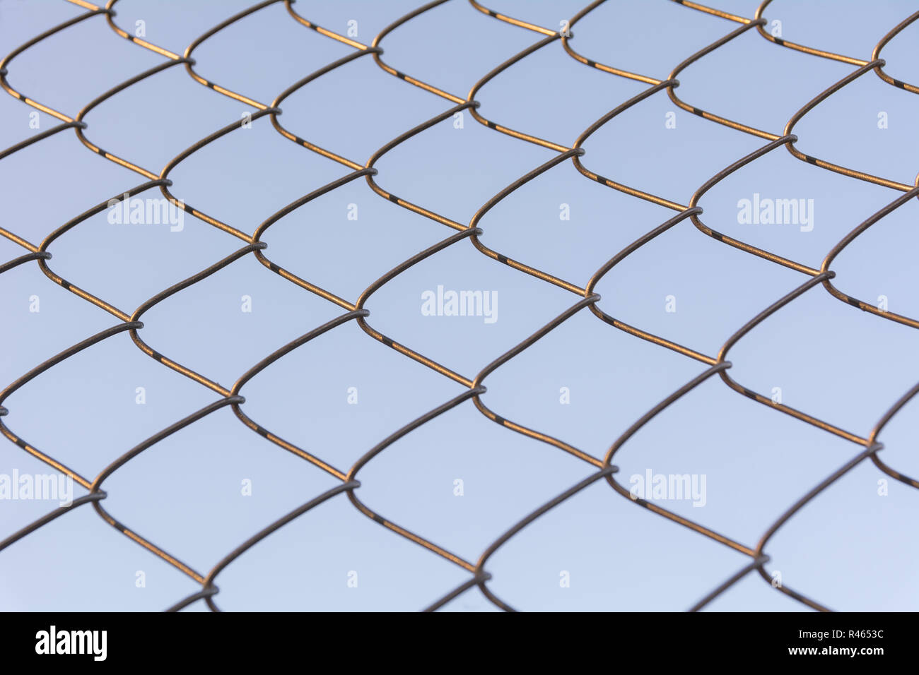 Old and rusty iron net wrapped on blue sky background. Stock Photo