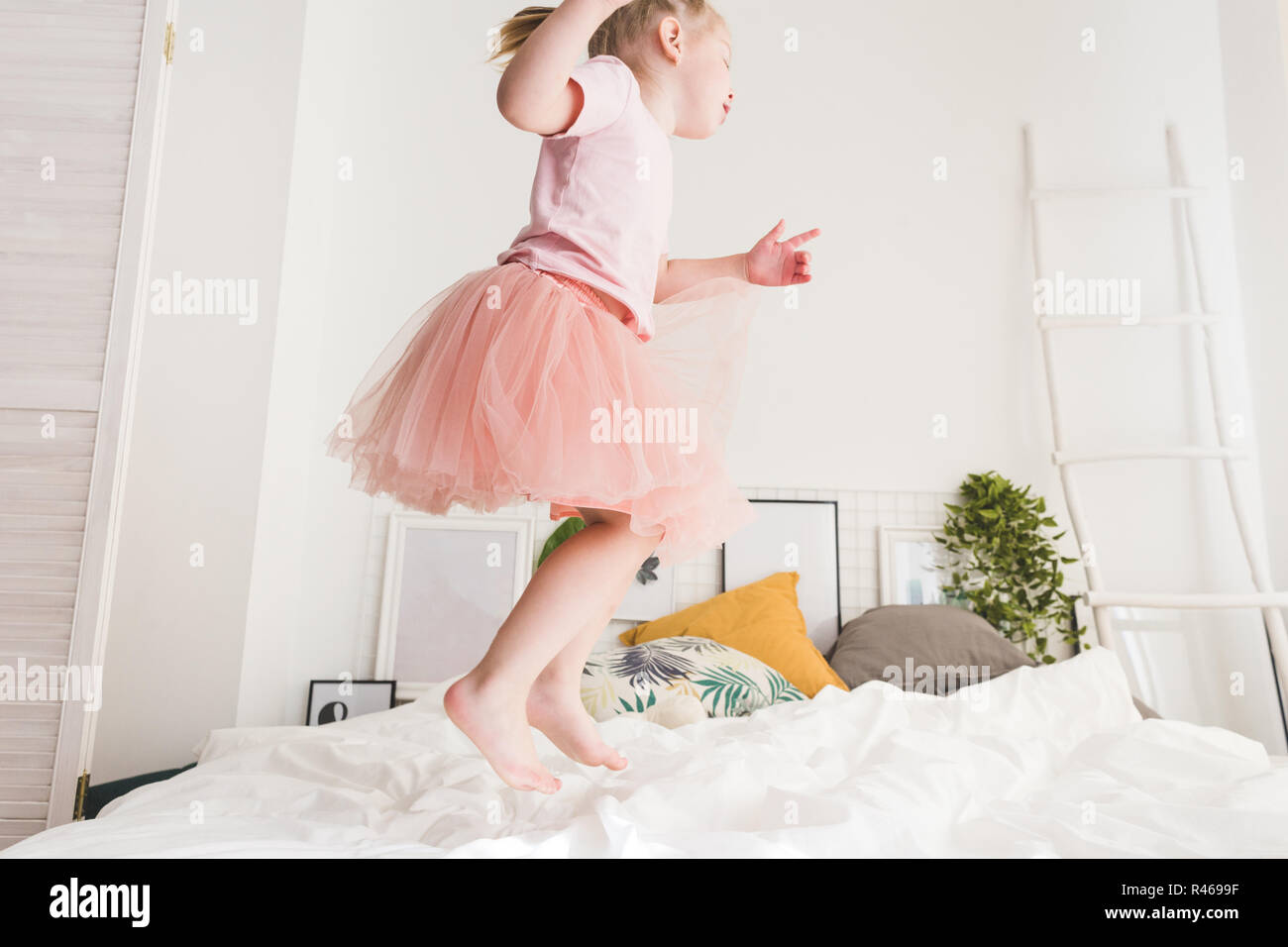 Cute little girl have fun on the bed at home Stock Photo - Alamy