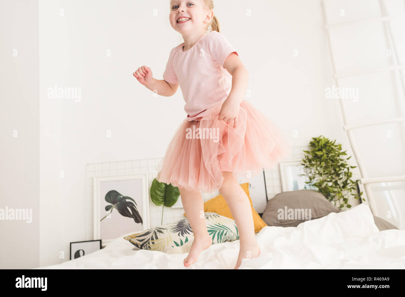 Cute little girl have fun on the bed at home Stock Photo - Alamy