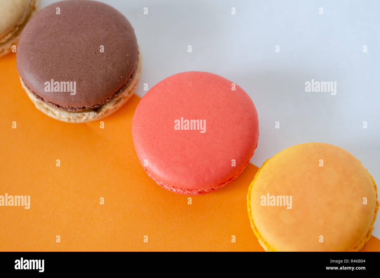 French macarons are on the orange-white background,top view. Stock Photo
