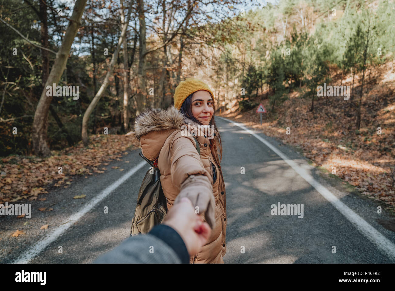 Young woman holding man's hand and leading him on nature outdoor. Couple in love Stock Photo