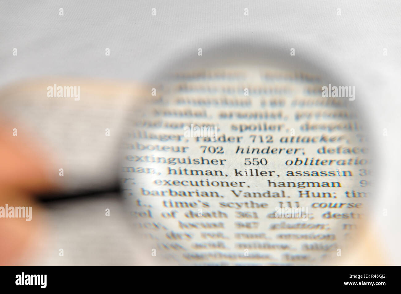 Hitman, killer and assassin words magnified on book Stock Photo