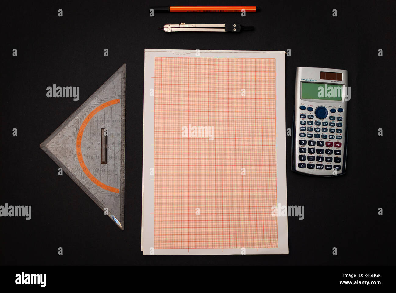 A pen, calculator, technical millimeter paper, set square and a circle on black background Stock Photo
