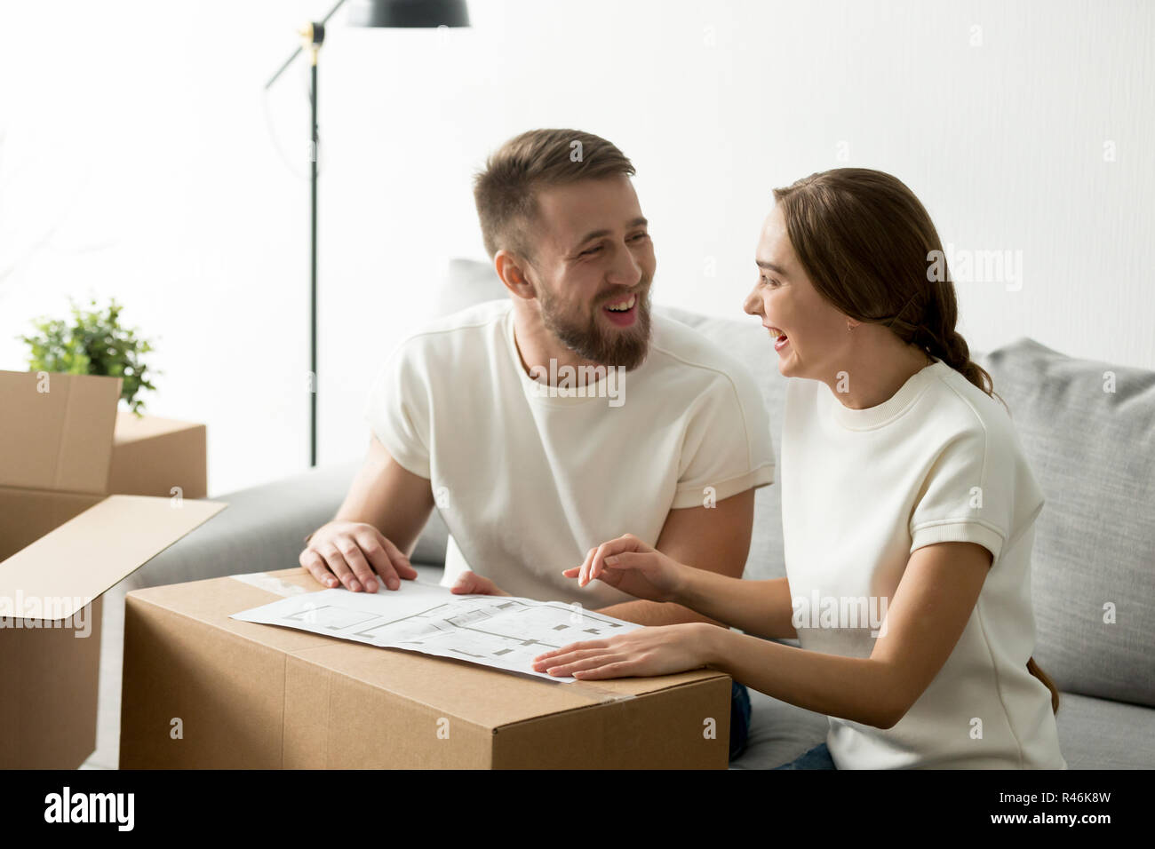 Happy laughing couple discussing house architectural plan Stock Photo