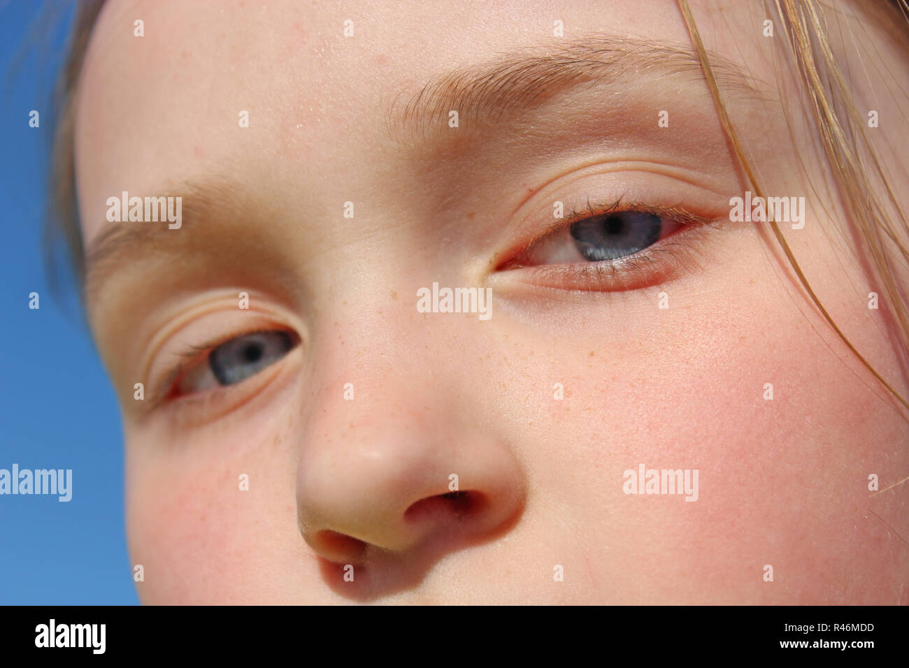 Face of teenager girl. Childish blue eyes staring up. Kid looking Stock Photo