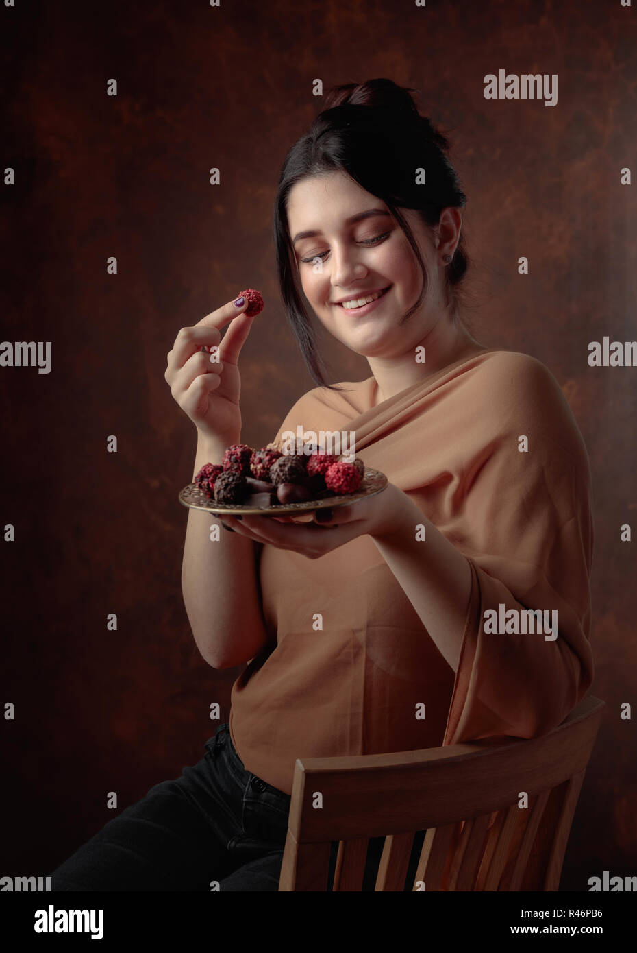 Portrait of a young beautiful girl with chocolate and candy. Stock Photo