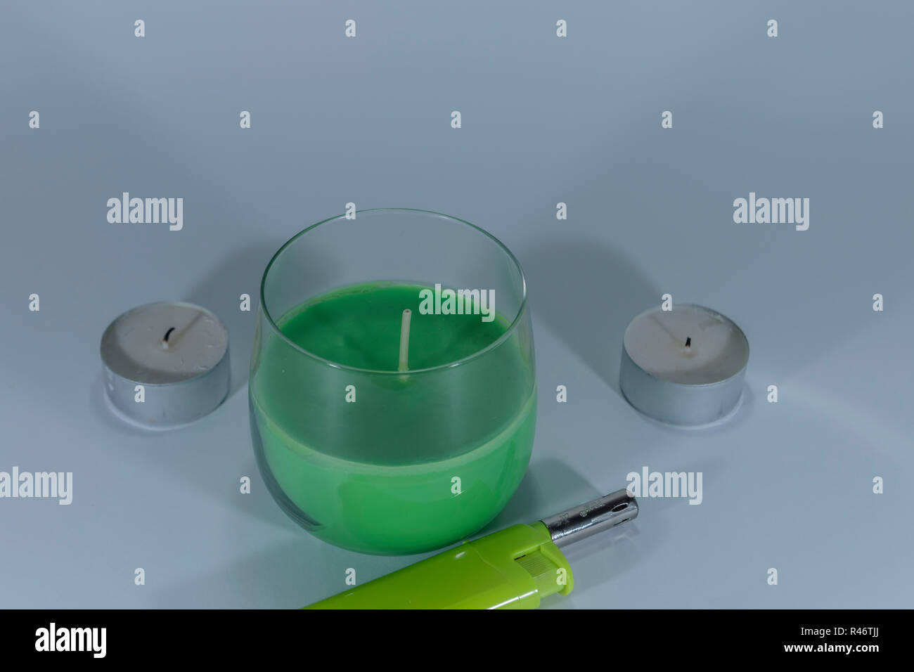Candles and a green lighter on white isolated background Stock Photo
