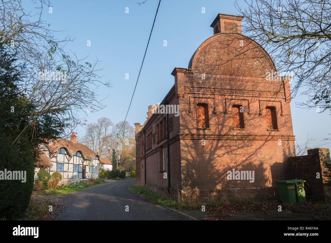 Masseys Folly, an ornate Victorian brick building built by Thomas Hackett Massey, and cottages in the village of Upper Farringdon, Hampshire, UK Stock Photo