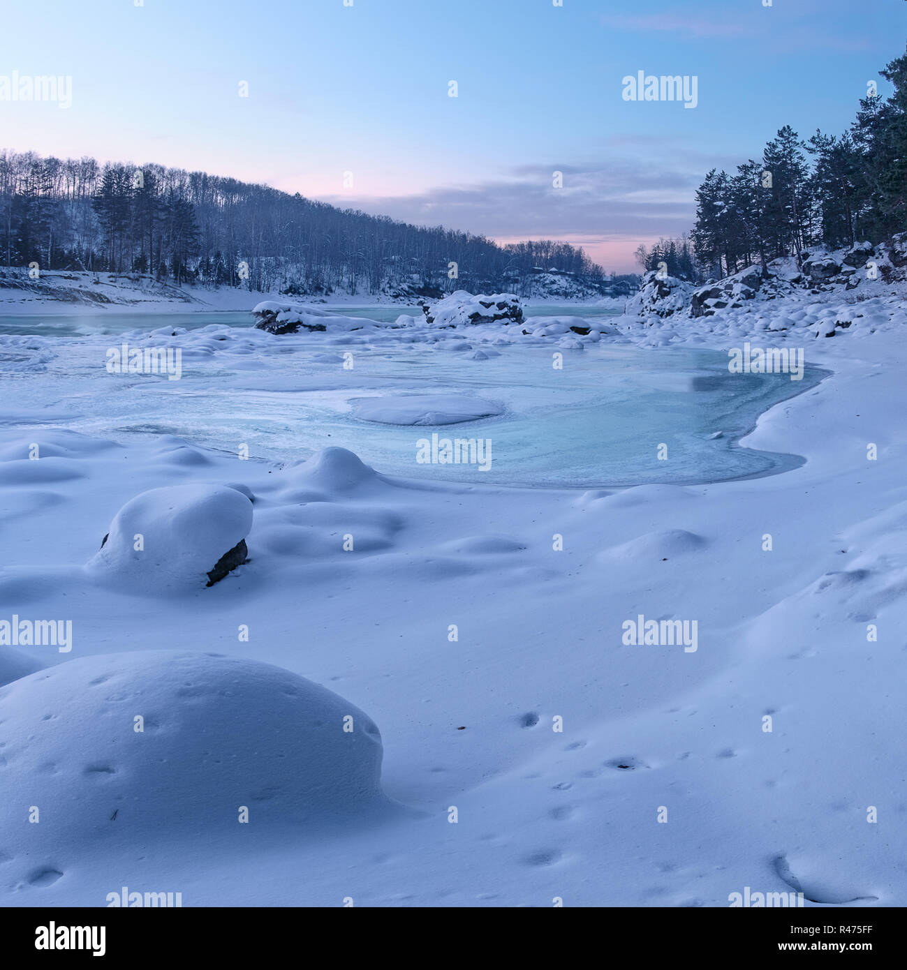 Frozen river and rocks covered with snow at sunset. Katun River, Mountain Altai, Siberia, Russia Stock Photo