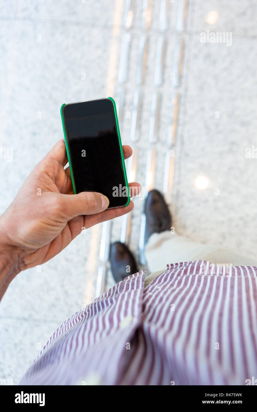 Close up of mobile phone with corporate environment blurred in the background. Stock Photo