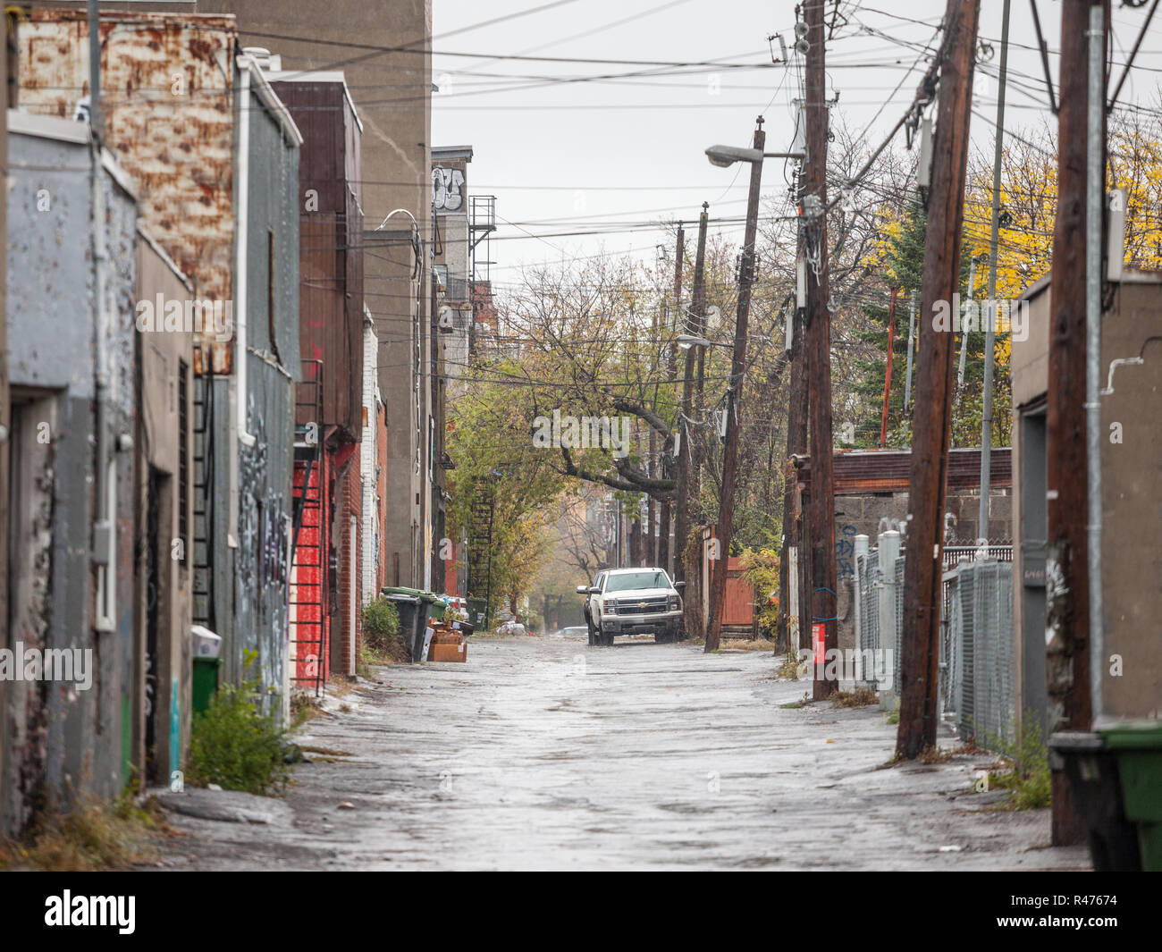 MONTREAL, CANADA - NOVEMBER 3, 2018: Dilapidated typical north American residential street in autumn in Montreal, Quebec, during a rainy day, with car Stock Photo