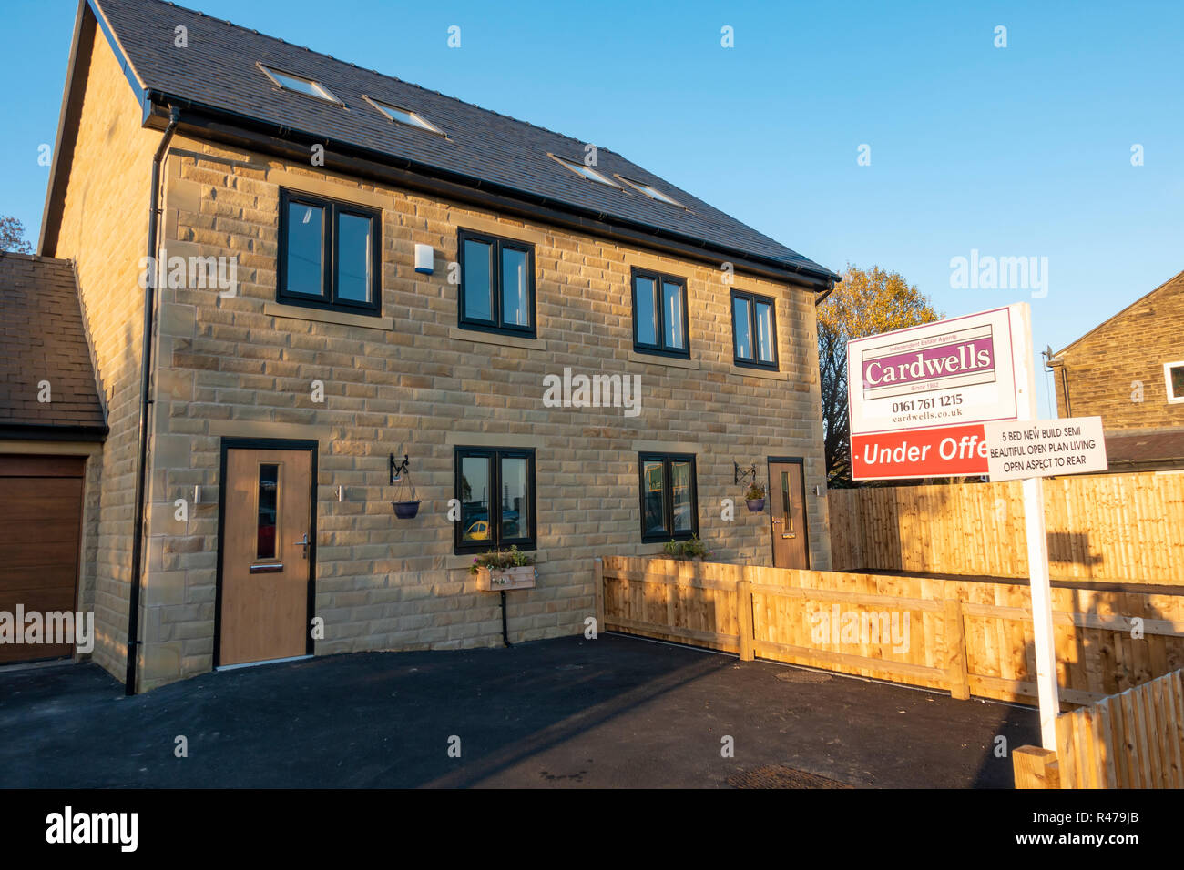 For Sale sign outside a brand new house Stock Photo