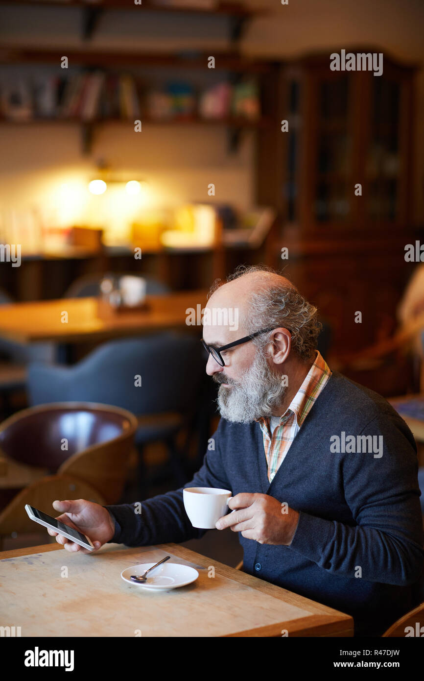 Texting by cup of tea Stock Photo