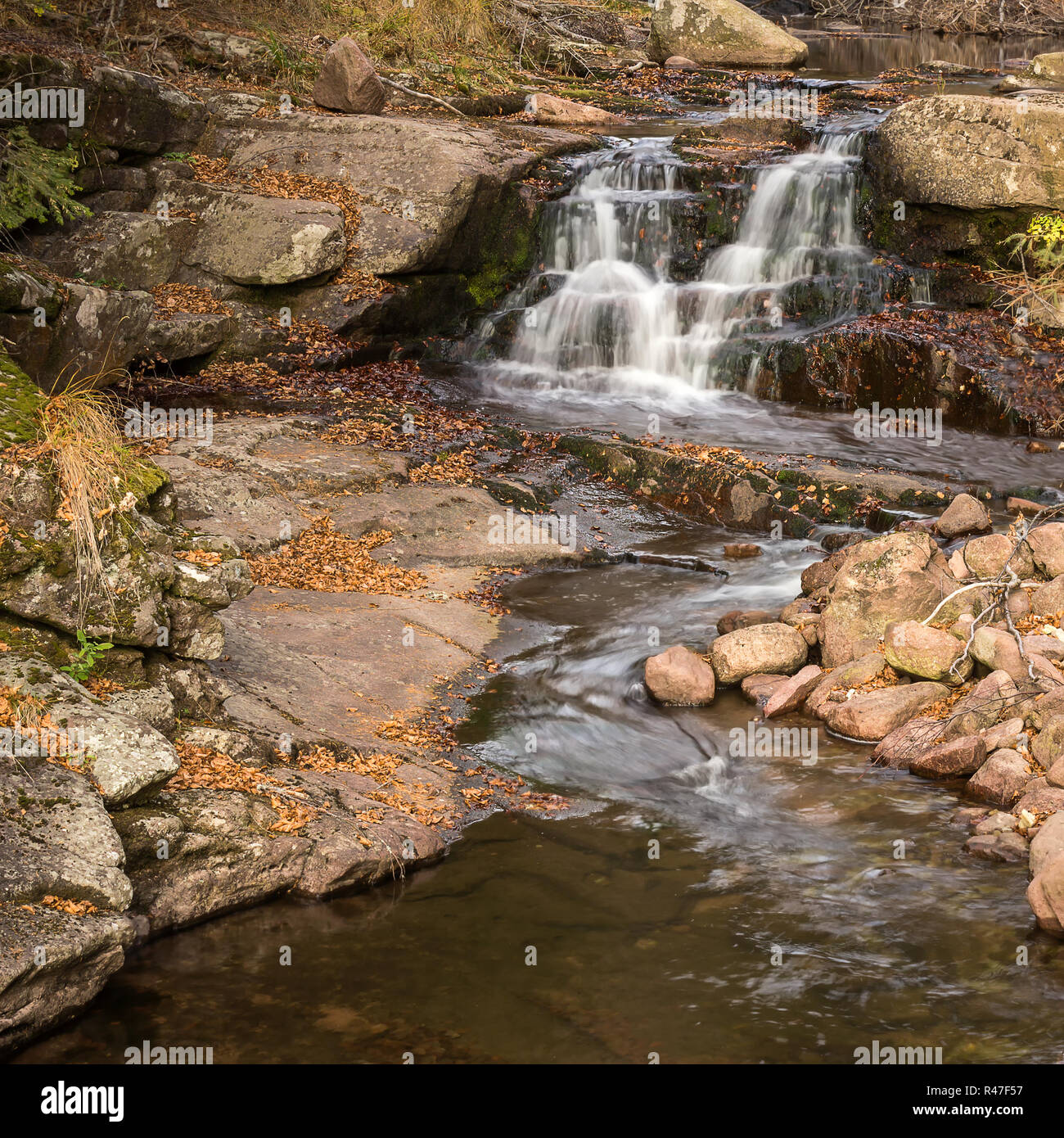 Beautiful autumn colors of cascading mountain creek and rocky bank ...