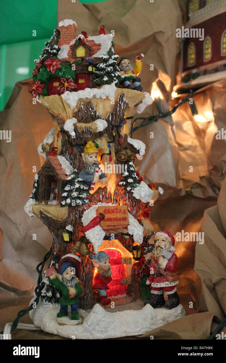 Miniature elf tree house with a Santa Claus displayed as Christmas holiday ornamental decorations. Stock Photo