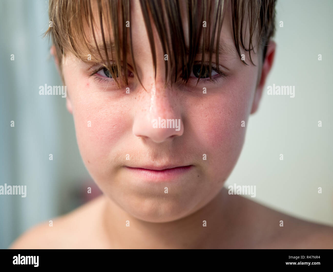 Close up portrait of teenage boy with long hair in need of haircut
