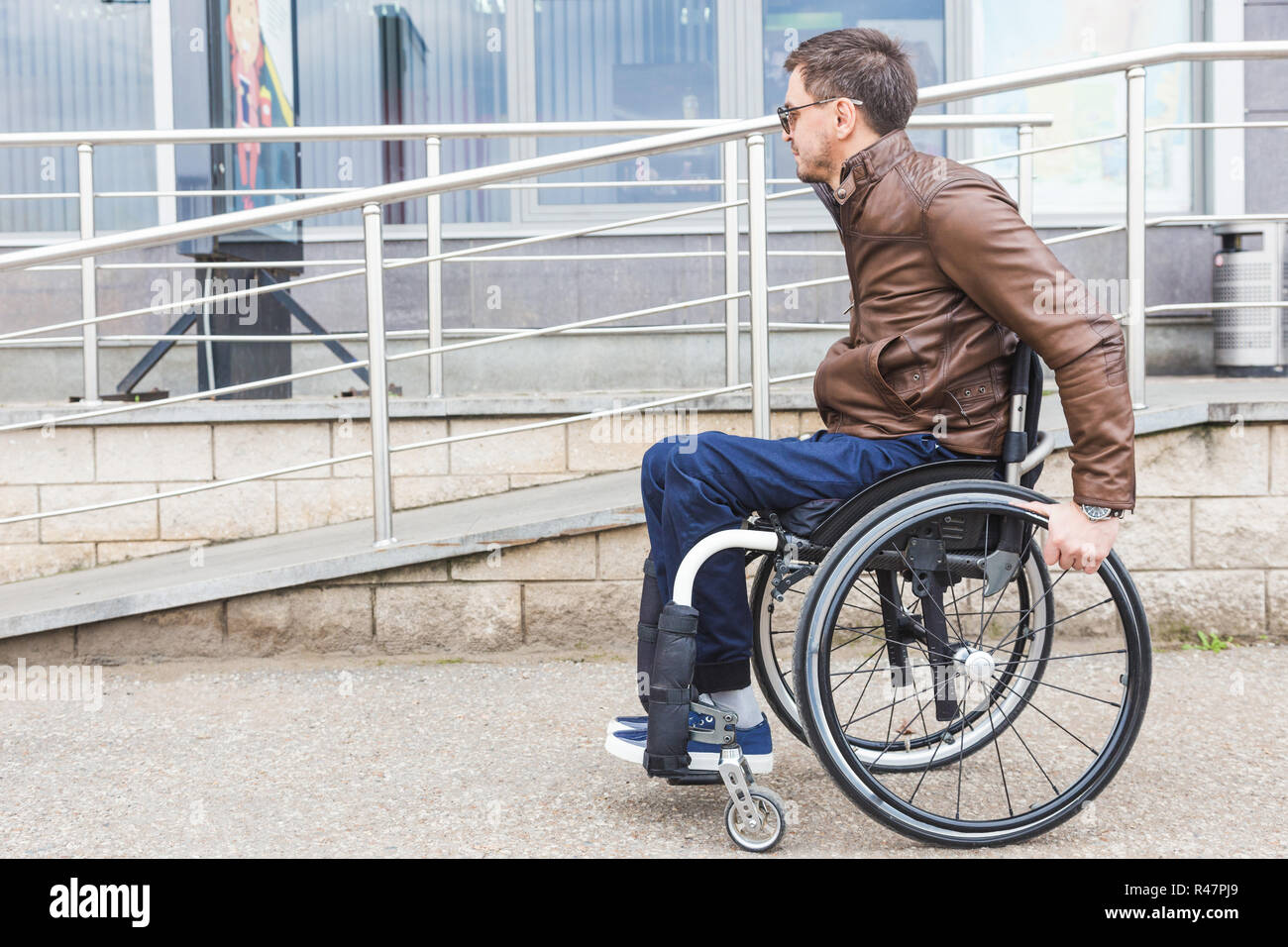 Man in a wheelchair use a wheelchair ramp Stock Photo - Alamy