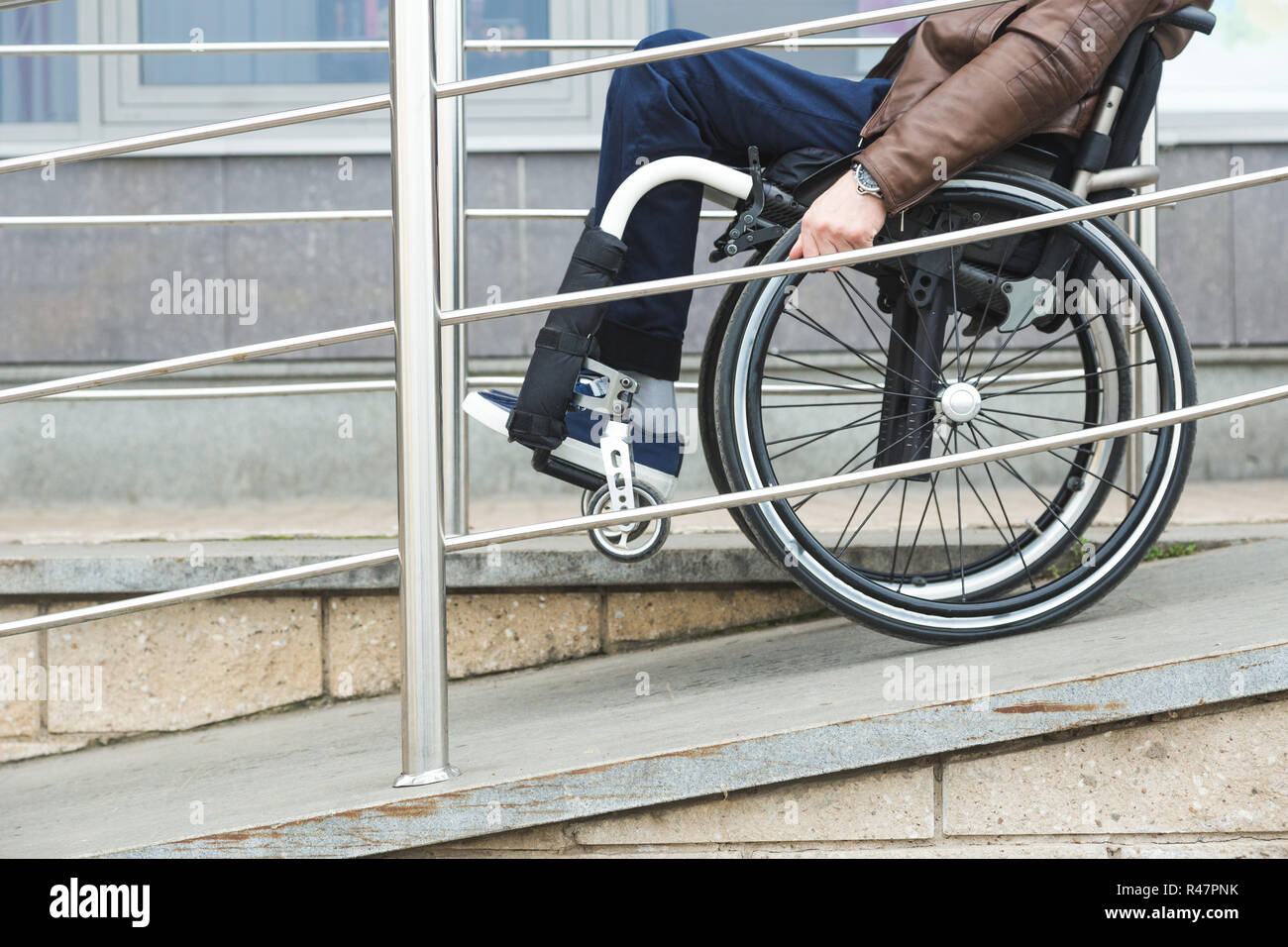 Man in a wheelchair use a wheelchair ramp Stock Photo - Alamy