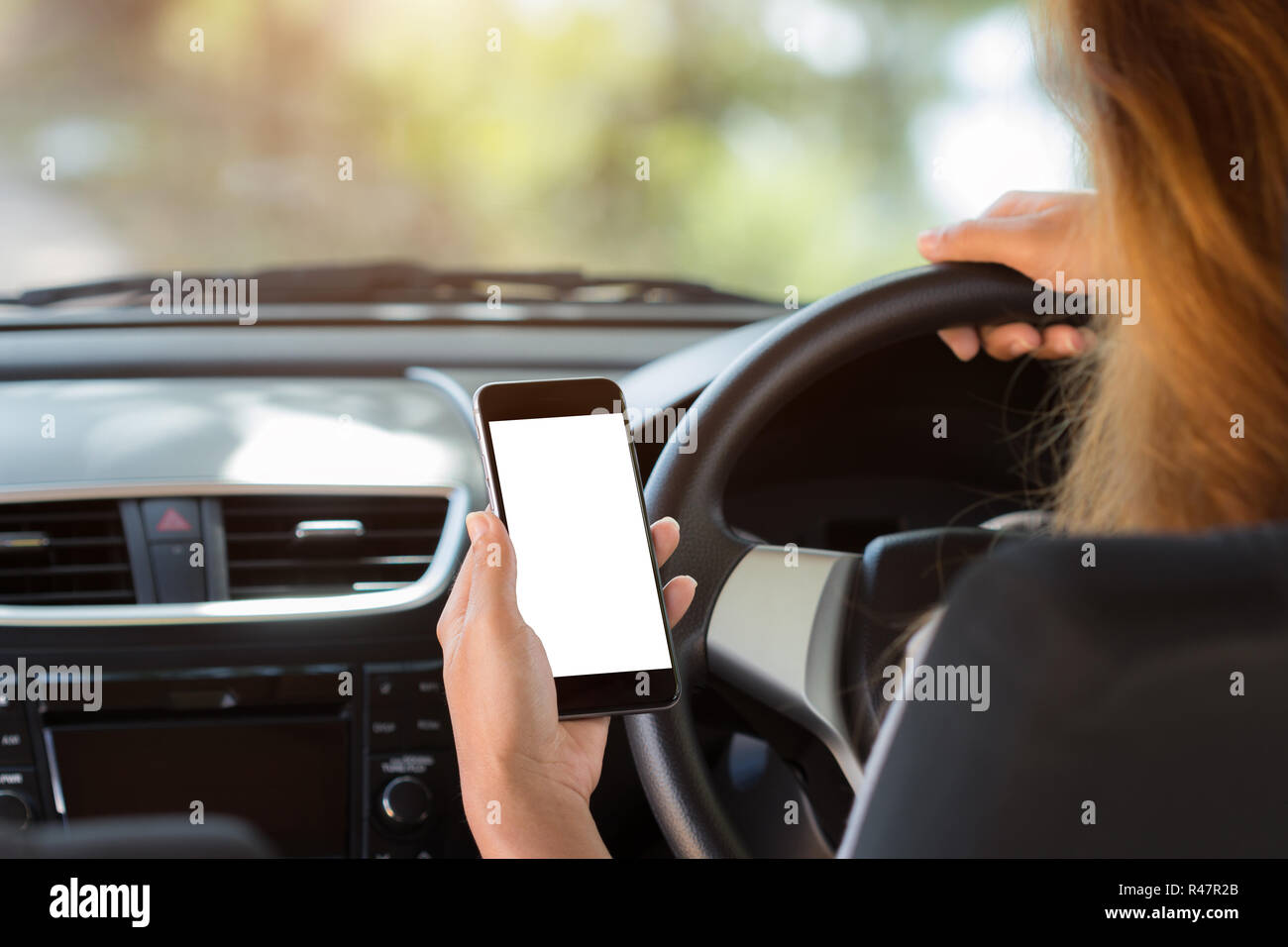 woman holding phone in car clipping path white screen Stock Photo