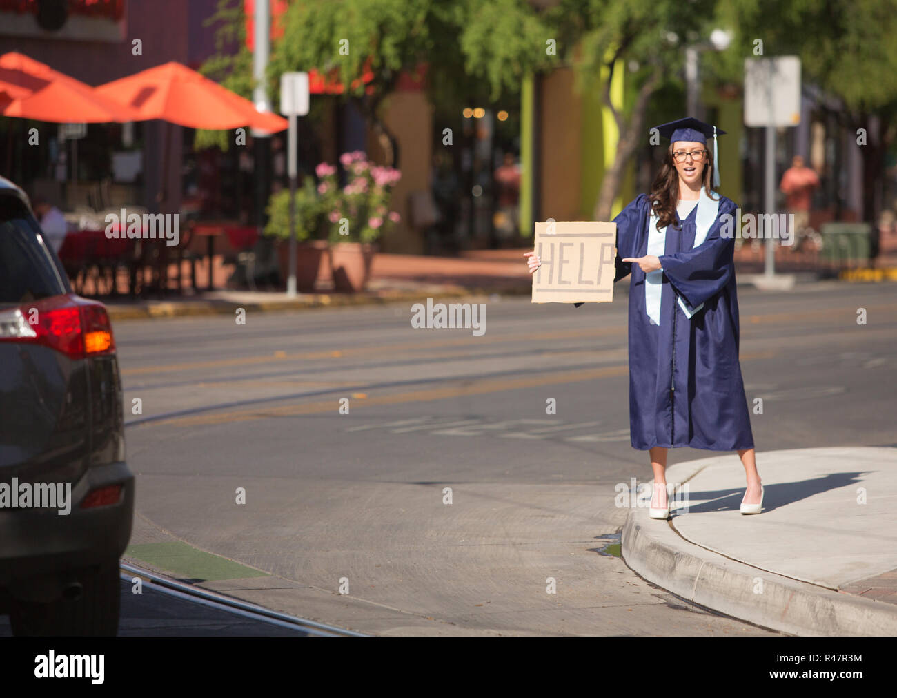 Graduate Pointing to Help Sign Stock Photo - Alamy