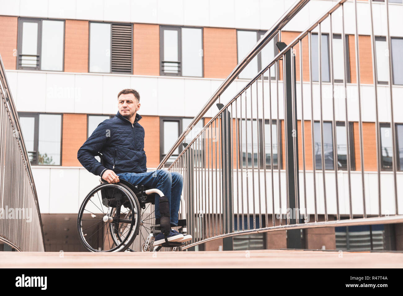 Man in a wheelchair use a wheelchair ramp Stock Photo - Alamy