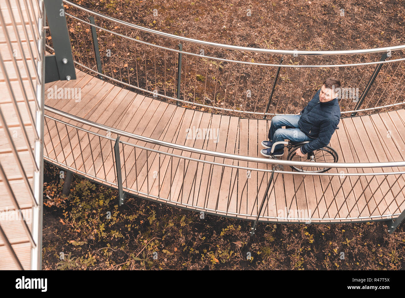 Man in a wheelchair use a wheelchair ramp Stock Photo - Alamy