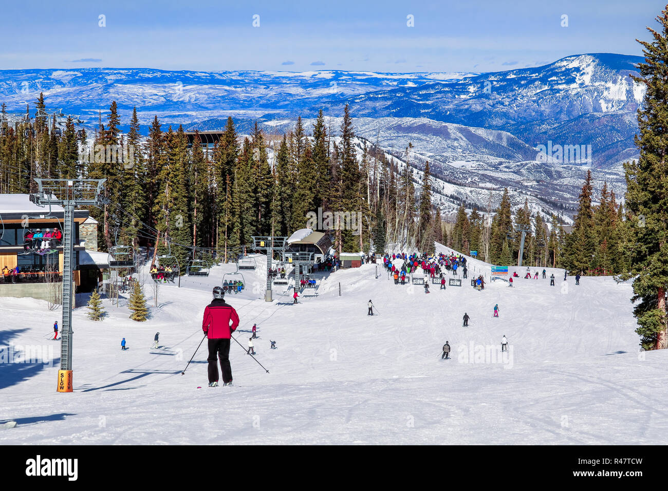 View of ski resort in Snowmass Mountain, Colorado, in the winter; skiers and snowboarders skiing down to the chairlift Stock Photo