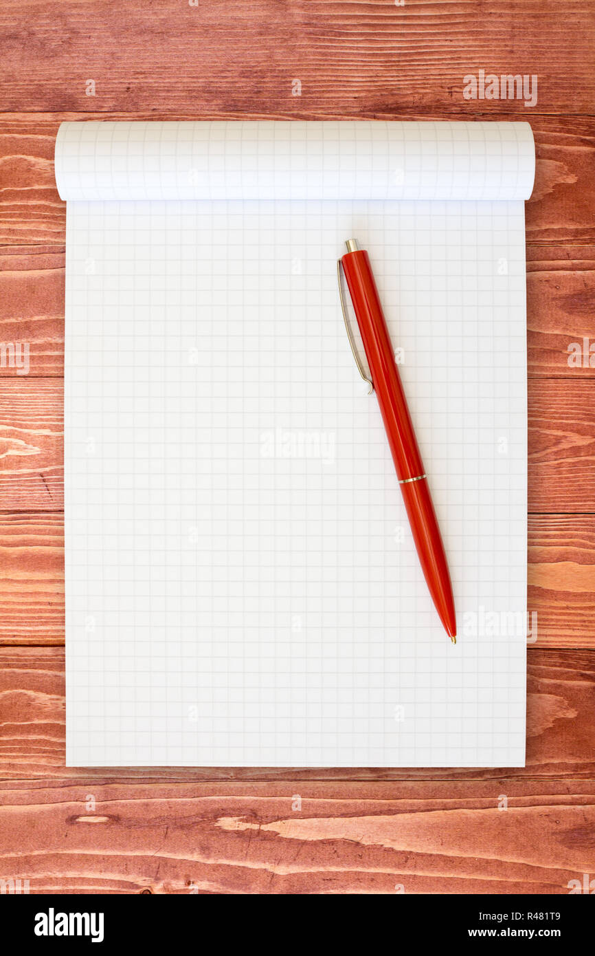 Notebook and red pen on the  wooden surface Stock Photo