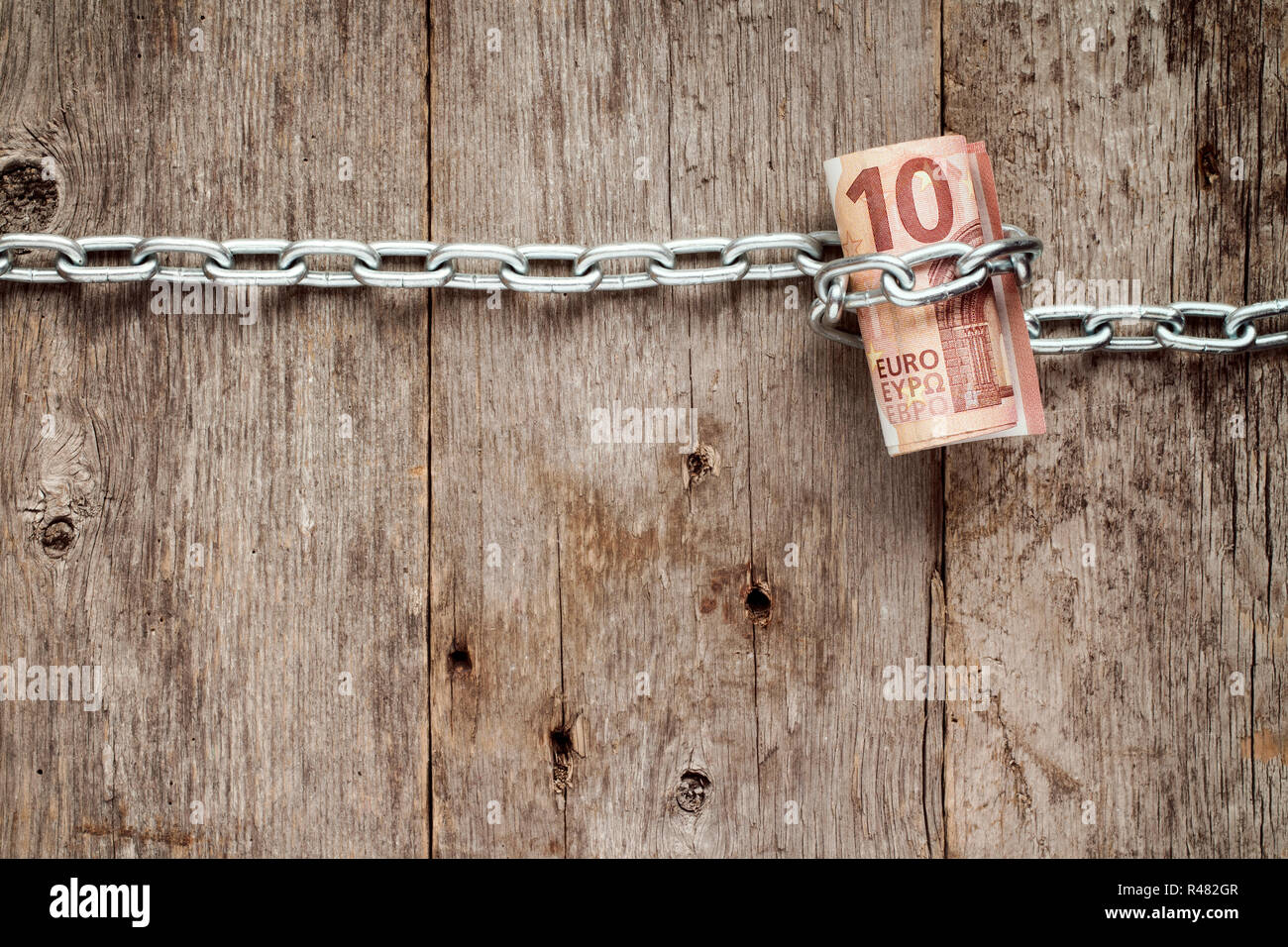 Rolled up Ten euro bills in chains Stock Photo