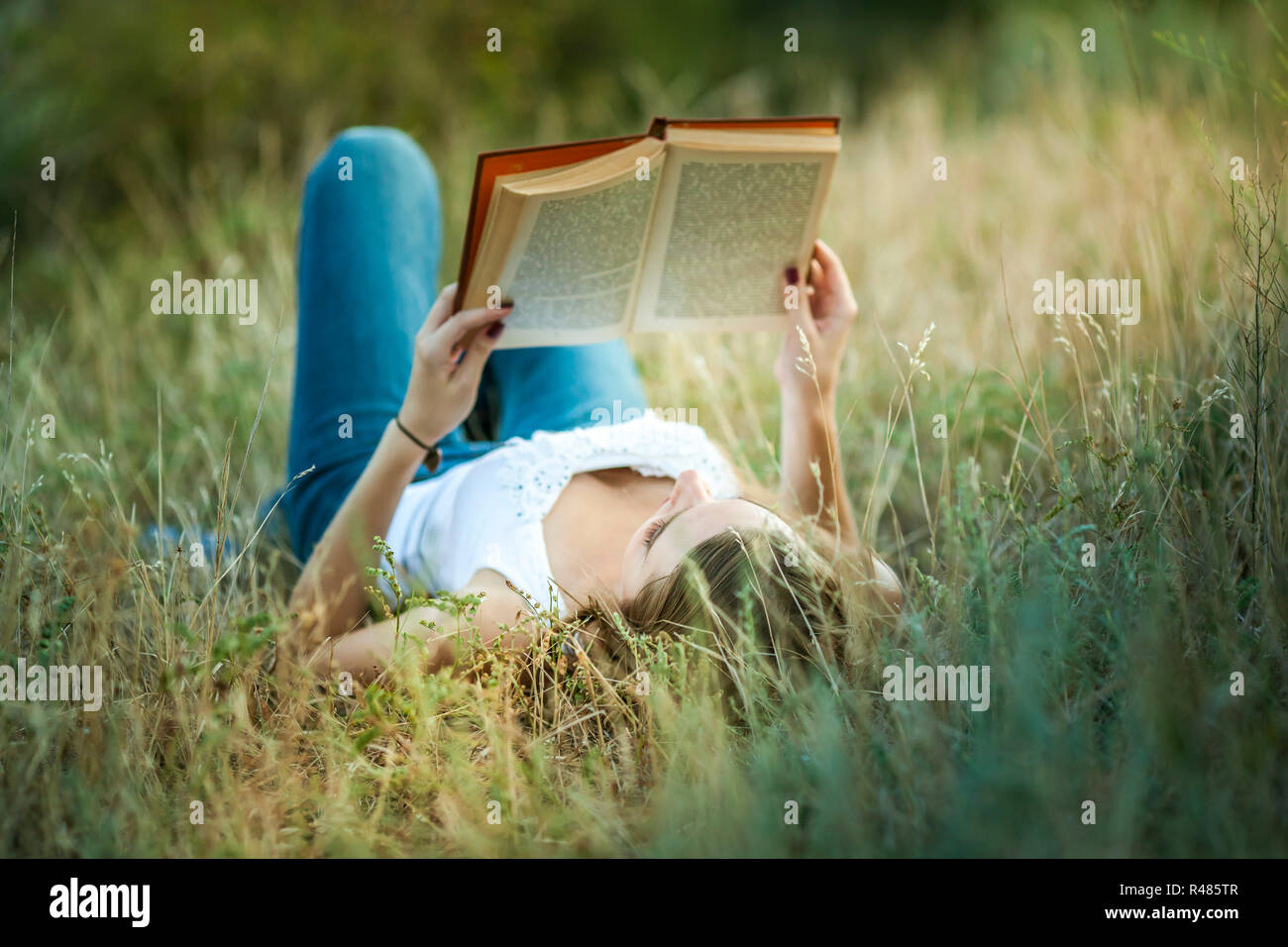 Beautiful girl reading a book on the Nature Stock Photo - Alamy
