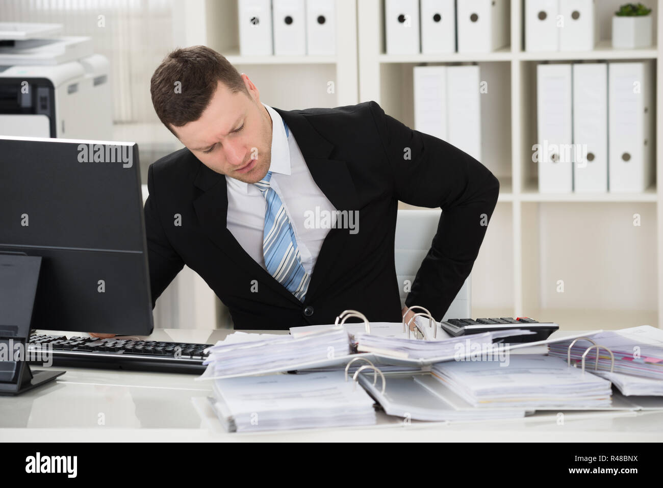 Businessman Suffering From Back Pain At Desk Stock Photo - Alamy